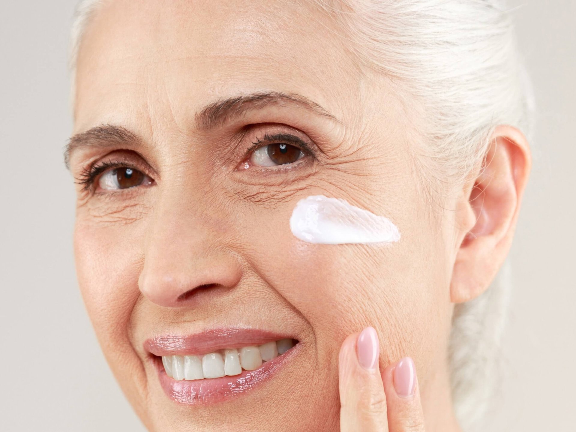 Mujer aplicándose crema con retinol de Loreal Paris